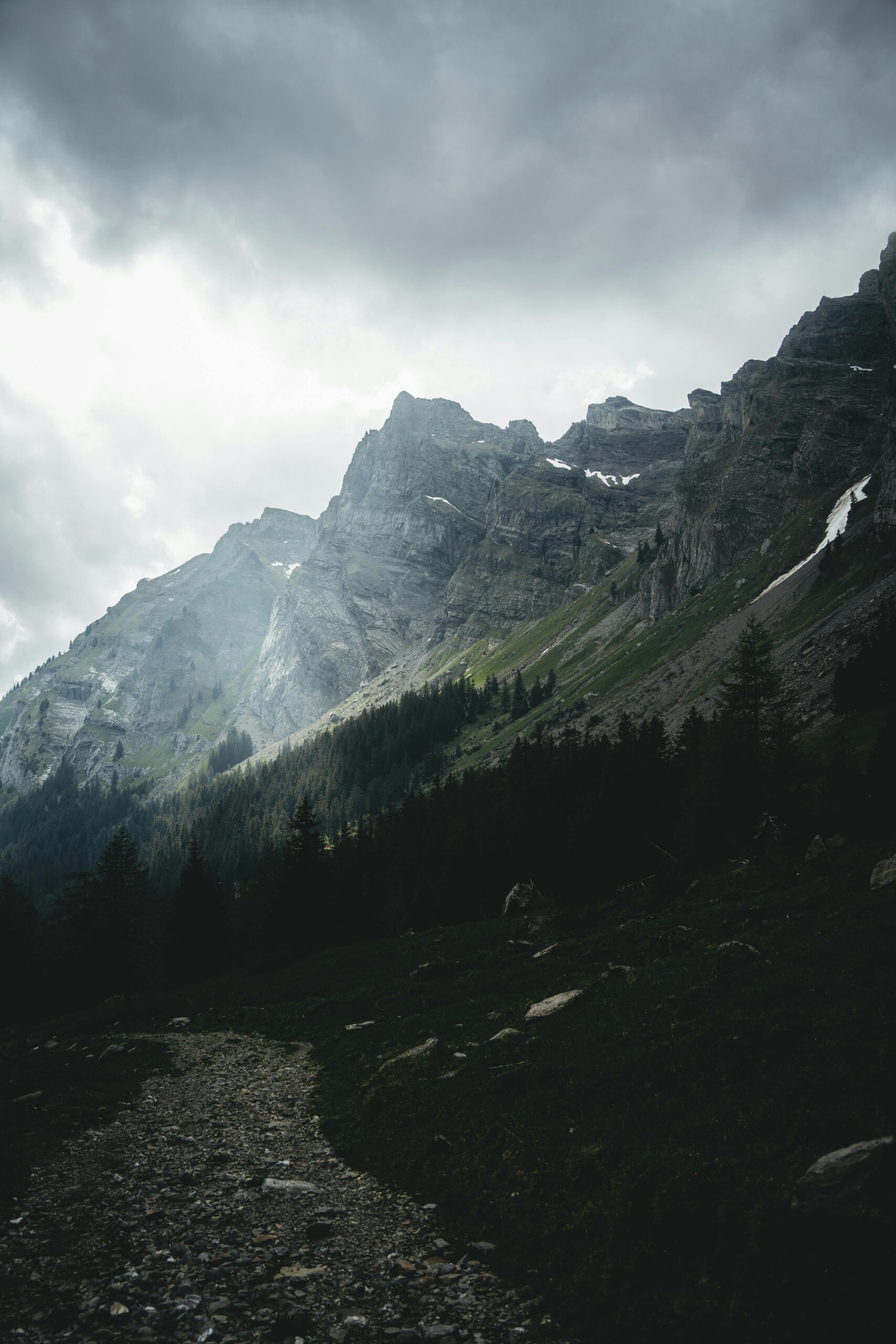 Moody mountain landscape in Gryon, Switzerland with gray clouds and rocky peaks.