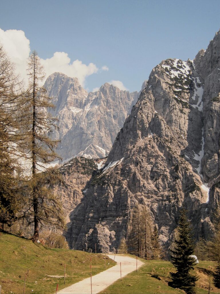Scenic view of the rugged European Alps in Slovenia featuring snow-capped peaks and lush greenery.